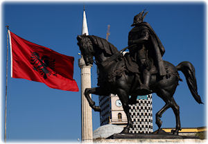 Das Abbild eines Reiters, zu dessen Seite die rot-schwarze Flagge Albaniens weht.