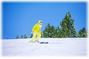 Andorra ist berühmt für die Ski-Gebiete: Hier eine begeisterte Snowboard-Fahrerin. Eine Person mit Skibrille kniet im Schnee und scheint begeistert.
