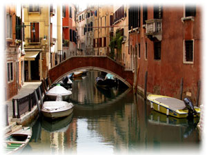 Die bekannten Wasserstraßen aus Venedig. Blick auf eine Häuserschlucht, in deren Mitte Wasser ist.