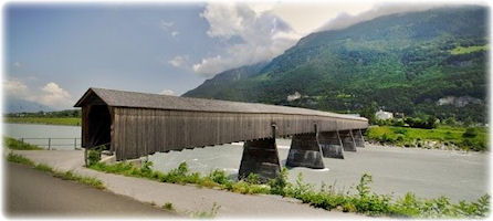 Diese alte Holzbrücke wirkt durch ihre Länge beeindruckend. Eine überdachte Holzbrücke ragt über den Rhein.