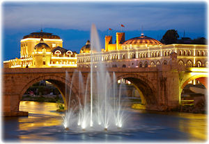 Die alte Brücke in Skopje bei Nacht mit imposanter Beleuchtung und einem Springbrunnen. Eine Aufnahme der alten Steinbrücke.