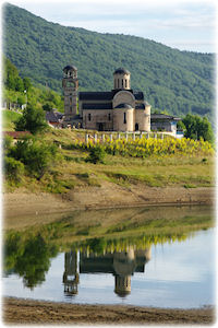 Dieses anmutige Gebäude ist die Kirche St. Nicholas, die am Mavrovo See liegt. Die Kirche St. Nicholas bei Tageslicht am See.
