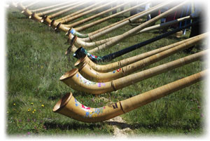 Das Alphorn spielt in der Schweiz eine große traditionelle Rolle. Vier traditioenlle Alphörnern mit ihren Spielern.