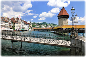 Luzern ist eine der beliebtesten Städte der Schweiz - zu sehen sind Brücken, die über den Fluss Reuss führen. Die Kapellbrücke führt über den Fluss Reuss in Luzern.