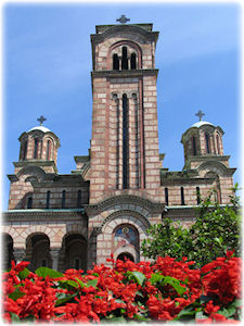 Ebenfalls ein Wahrzeichen Belgrads: Die Sveti Marko Kirche. Aufnahme einer Kirche in Belgrad mit Blumen davor.
