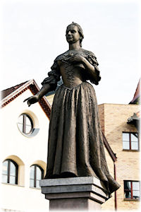 Eine Statue in der geteilten Stadt Komorn in der Slowakei. Eine Frau auf einem Sockel als Statue.