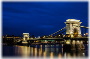 Die Kettenbrücke in Budapest beeindruckt durch ihre Größe und Konstruktion. Die Kettenbrücke in Budapest, beleuchtet und bei Nacht.